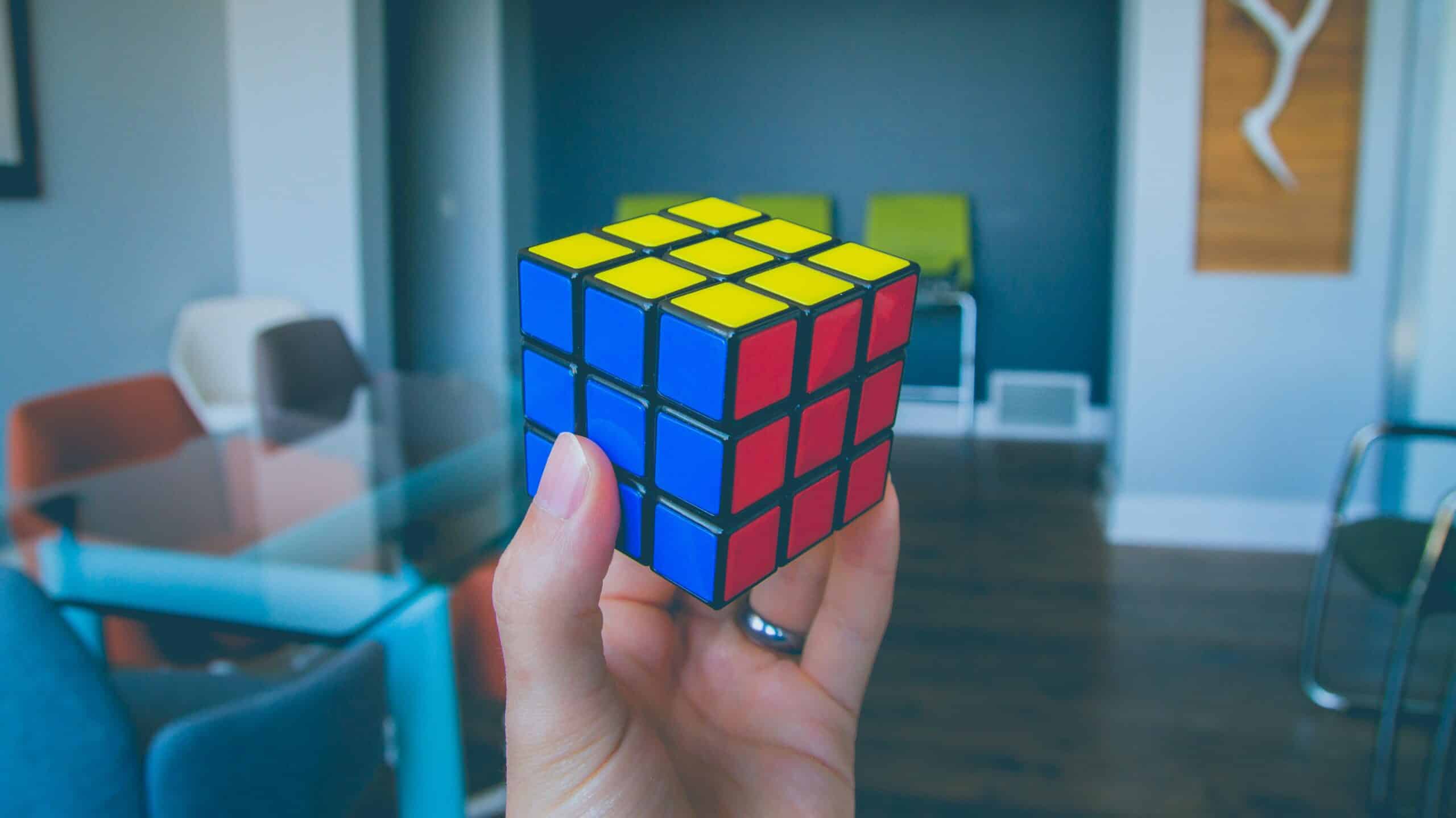 Une main tient un Rubik's cube résolu