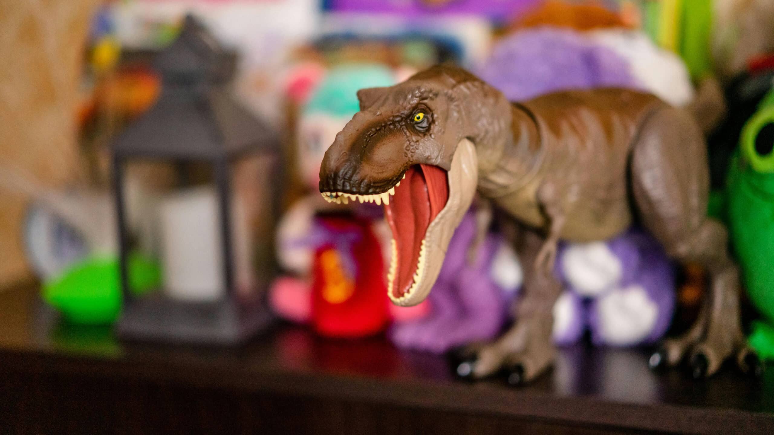 Un dinosaure avec la gueule ouverte dans une chambre d'enfant.